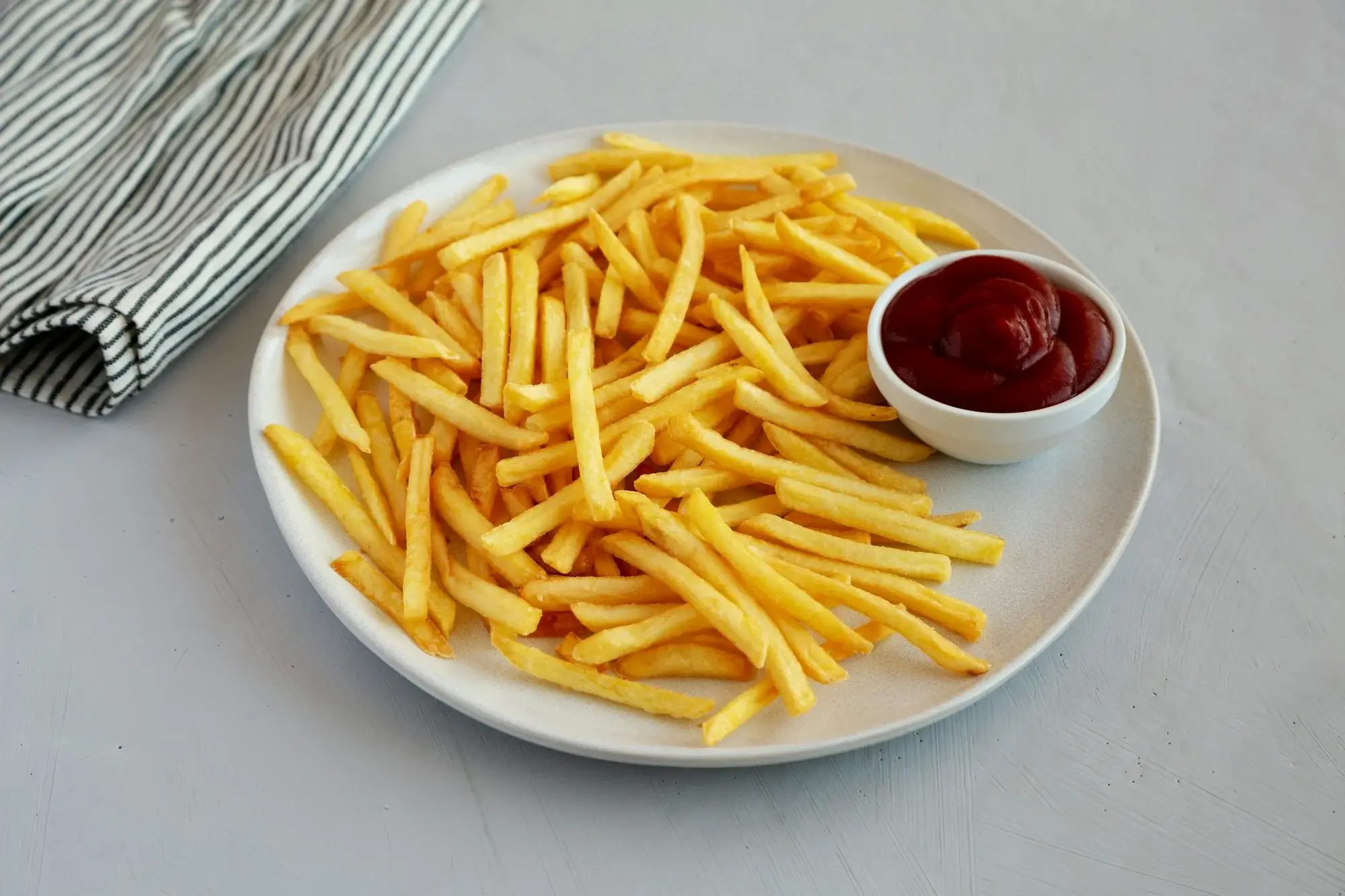 Pommes in der Heißluftfritteuse goldbraun und knusprig.